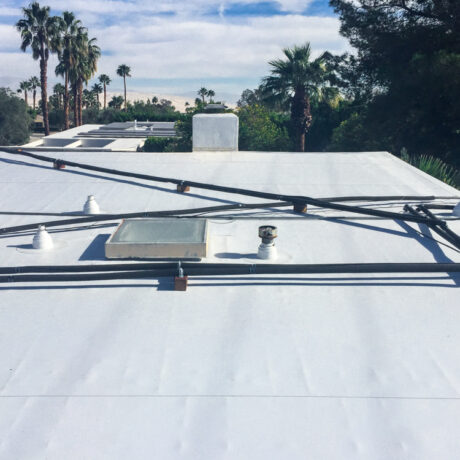 Roofing professional applying protective coating to extend roof lifespan
