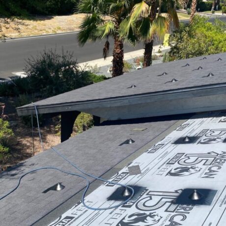 Applying SPF (Spray Polyurethane Foam) roofing system on a flat roof in the Palm Desert area under clear skies
